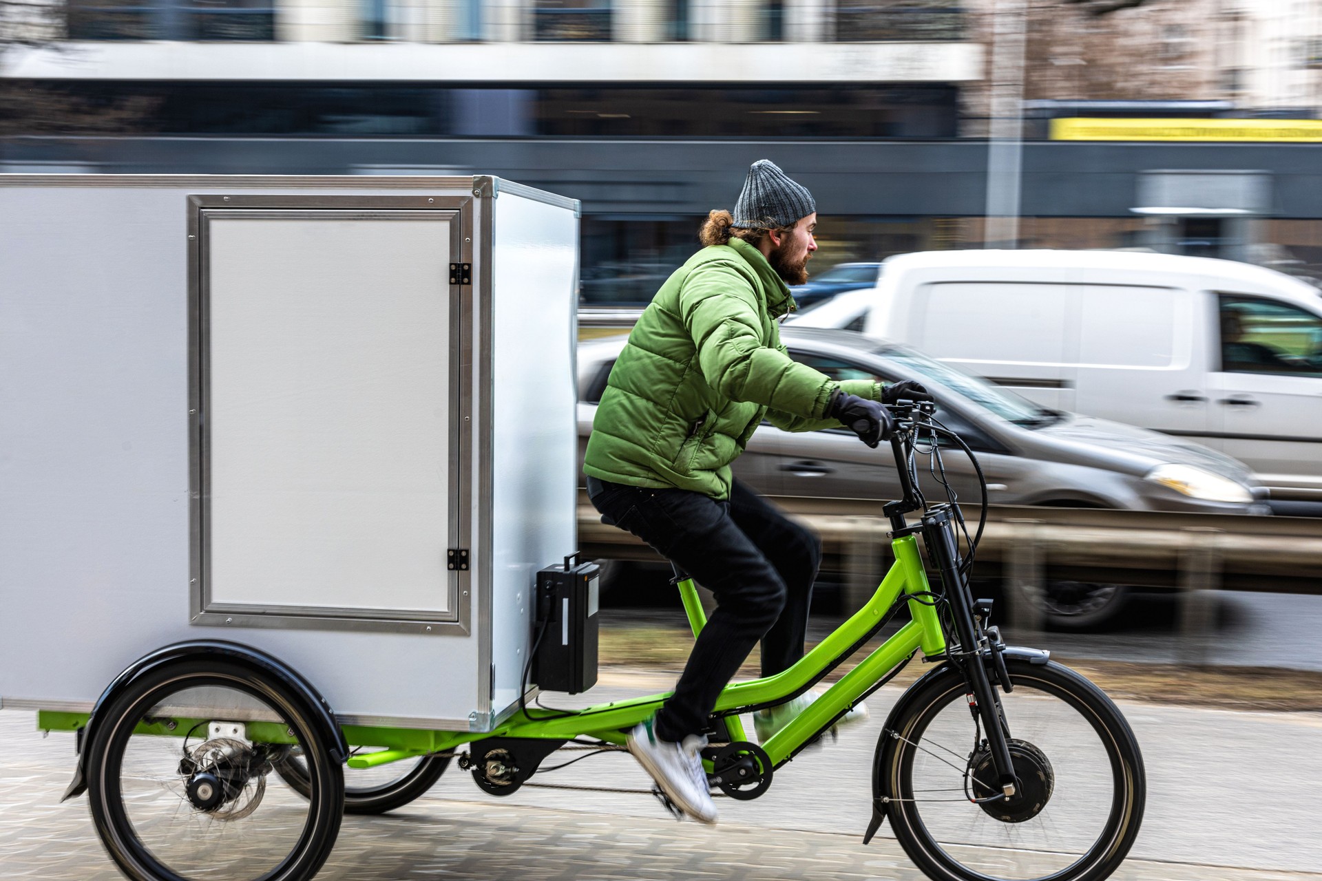 Bicycle courier delivering parcels in the city on a cargo bike
